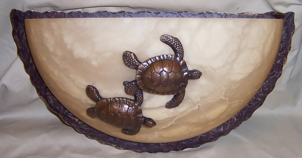 Two bronze turtles are sitting in a bowl.