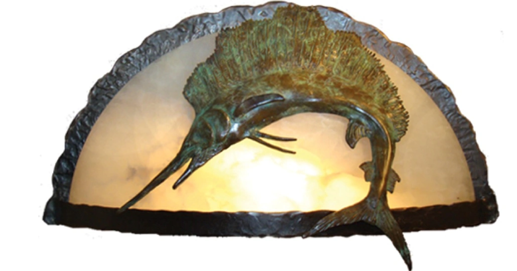 A bronze sculpture of a fish on top of a rock.