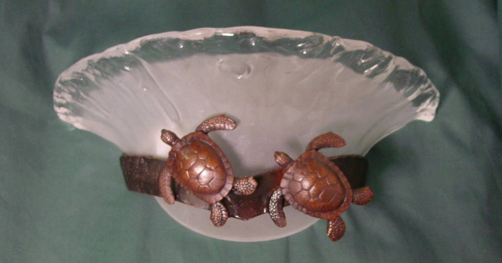 Two bronze turtles are sitting on a white plate.