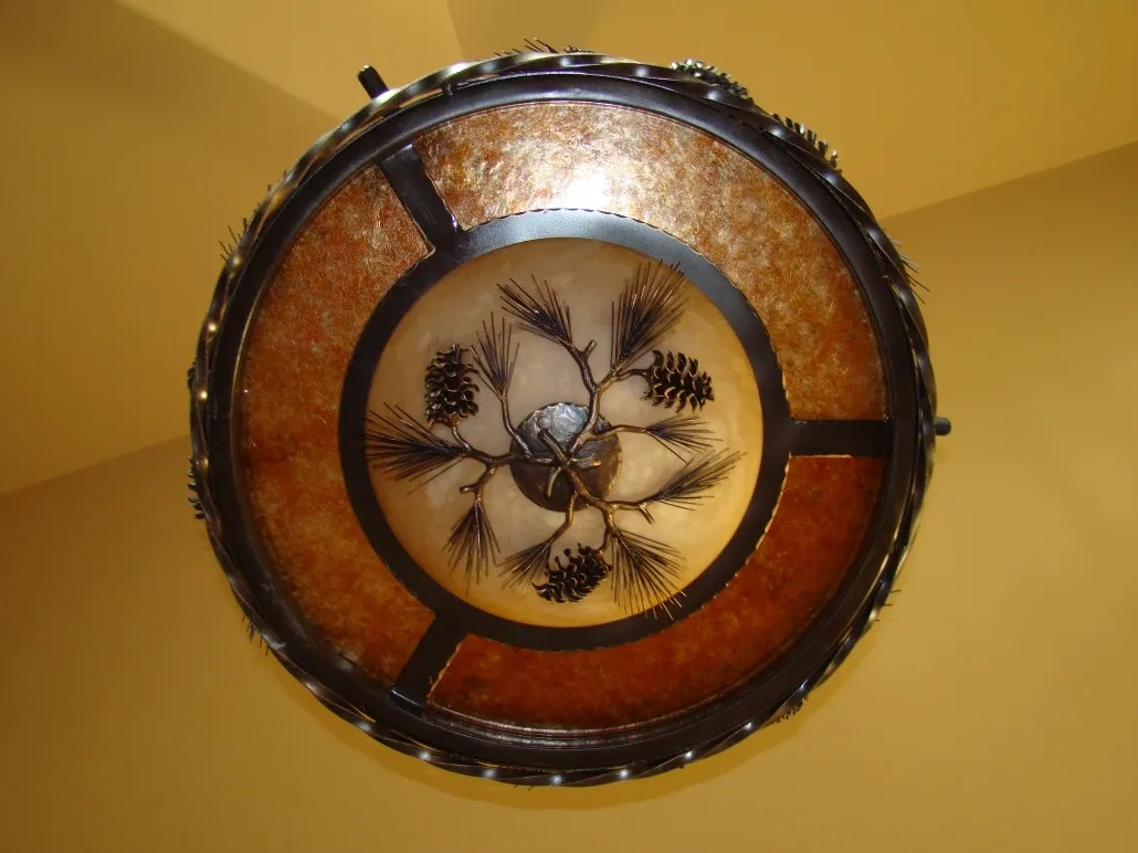 A ceiling light with pine cones on it.