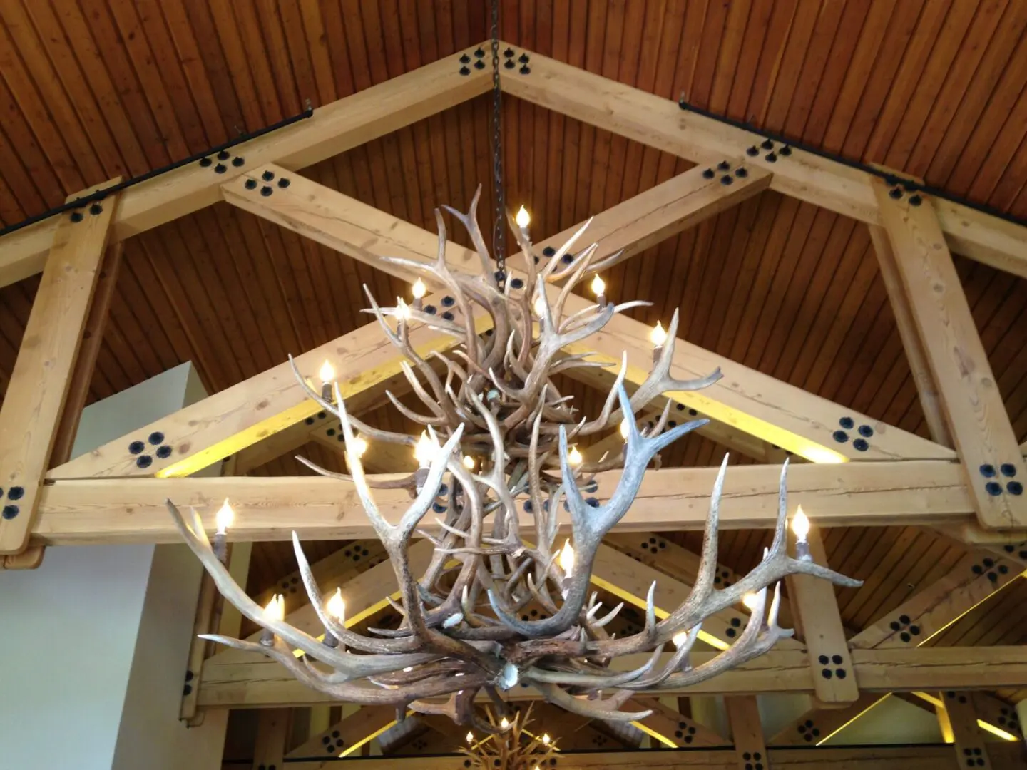 A chandelier with antlers hanging from the ceiling.