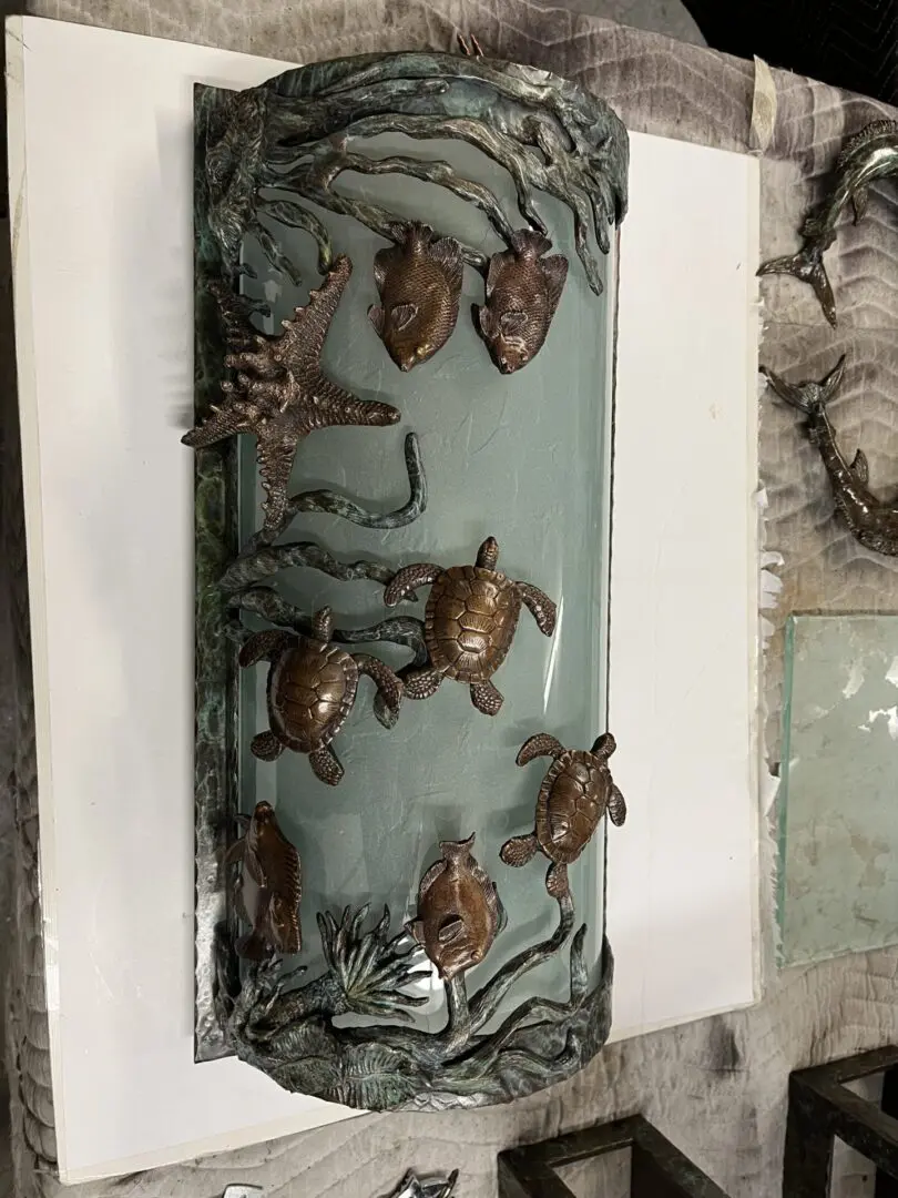 A glass panel with bronze turtles on it.