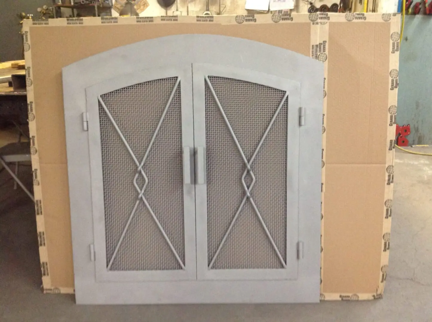 A white door with metal grill and handles.