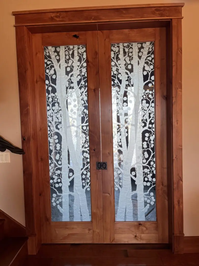 A door with two trees on it and glass