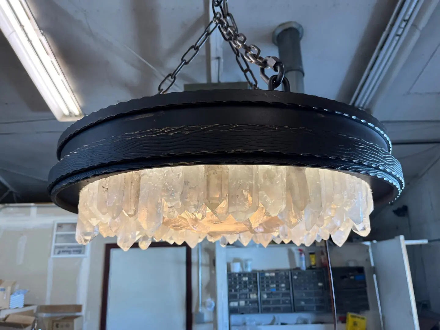 A black metal light fixture with white lights hanging from the ceiling.