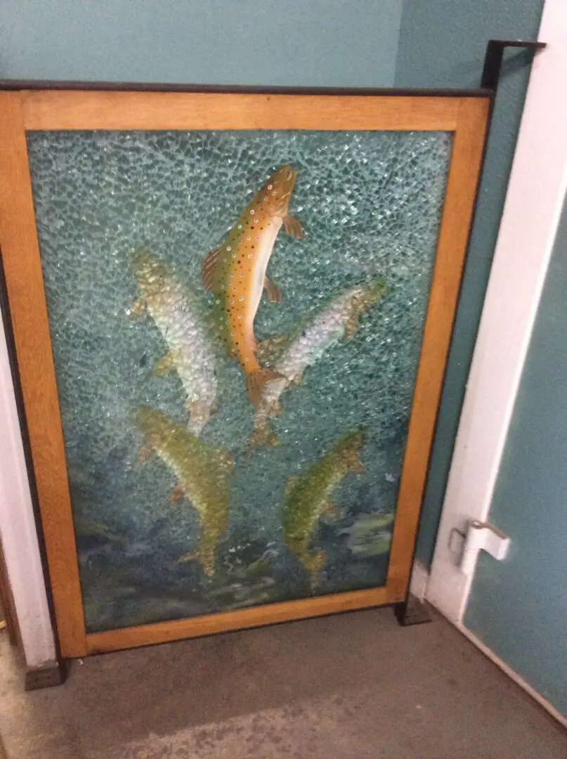 A painting of fish on the wall in a room.