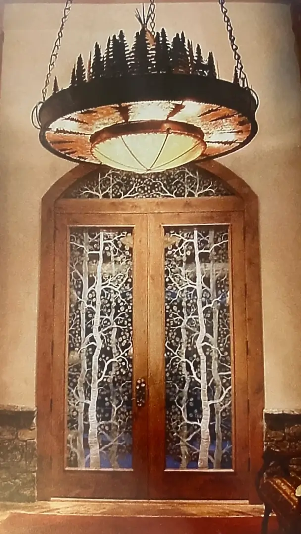 A door with two wooden doors and trees on the side.